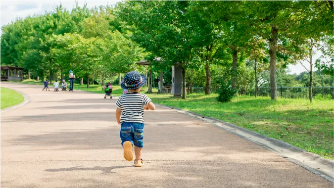 福岡市城南区の土地について徹底解説、広い公園ではしゃぐ子供の後ろ姿